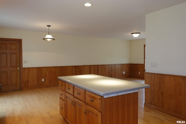 50 Hackberry Cir, Galesburg, IL 61401 - kitchen with wainscoting, wood walls, light wood finished floors, brown cabinets, and a center island