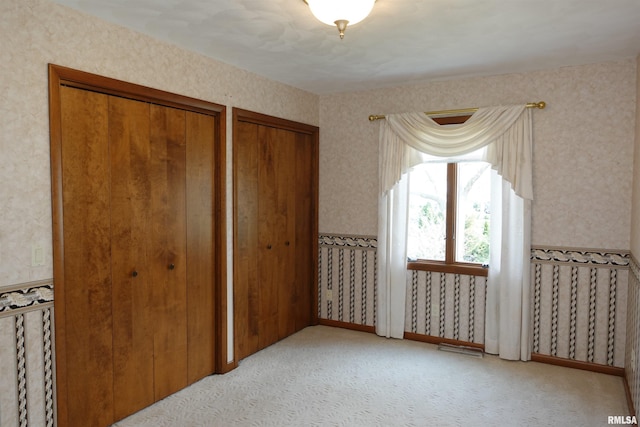50 Hackberry Cir, Galesburg, IL 61401 - unfurnished bedroom with two closets, wallpapered walls, and light colored carpet