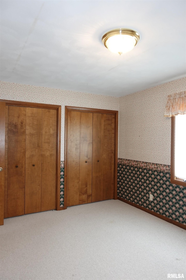 50 Hackberry Cir, Galesburg, IL 61401 - unfurnished bedroom featuring wallpapered walls, multiple closets, and carpet floors