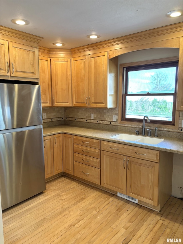 2110 Magnolia Dr, Jacksonville, IL 62650 - kitchen with freestanding refrigerator, decorative backsplash, visible vents, a sink, and light wood finished floors