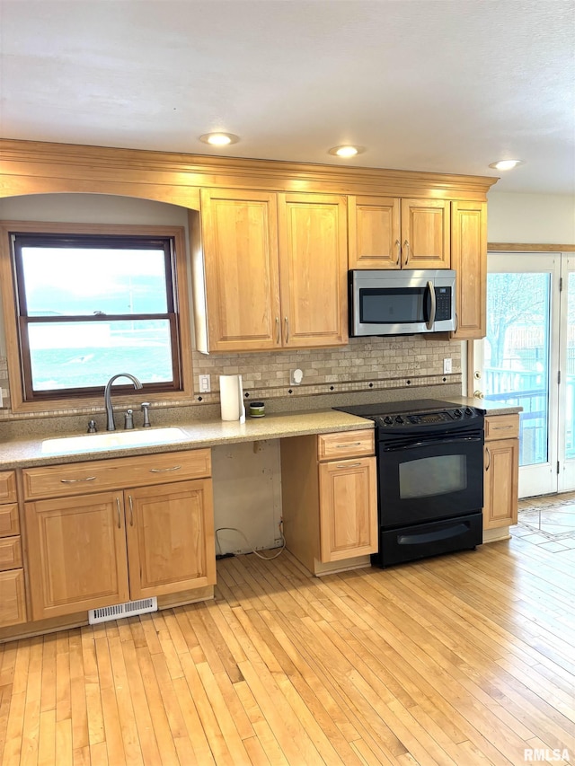 2110 Magnolia Dr, Jacksonville, IL 62650 - kitchen with black / electric stove, stainless steel microwave, plenty of natural light, and a sink
