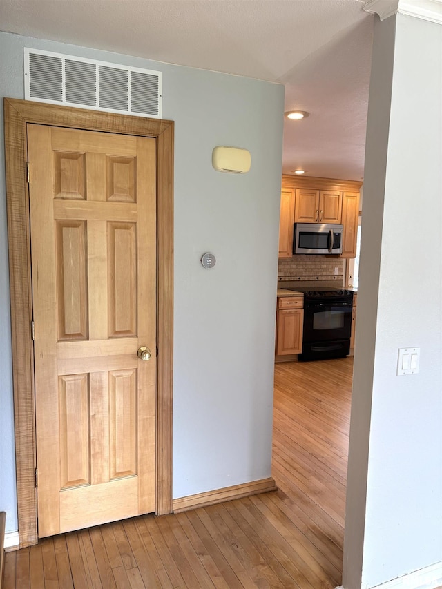 2110 Magnolia Dr, Jacksonville, IL 62650 - hallway featuring wood finished floors, baseboards, visible vents, and recessed lighting
