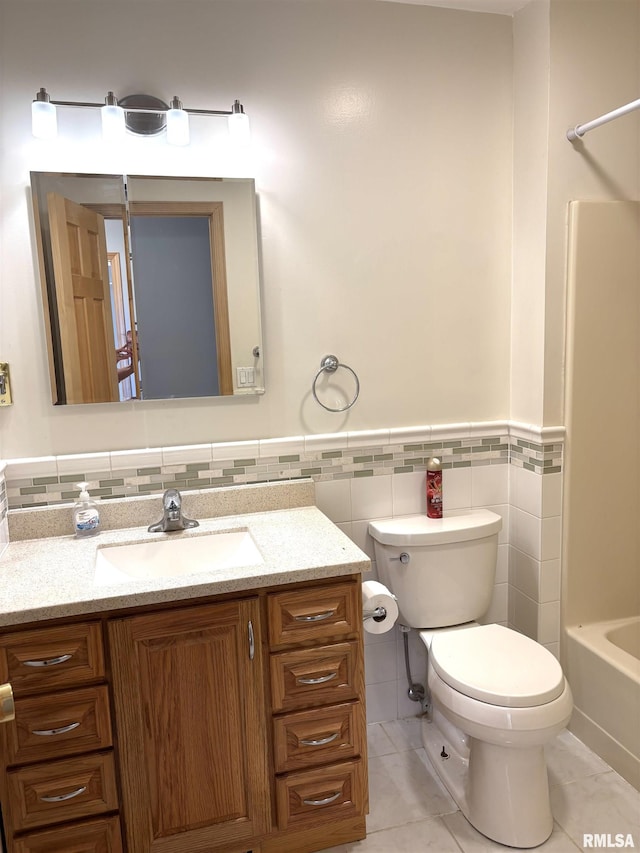 2110 Magnolia Dr, Jacksonville, IL 62650 - full bath featuring vanity, toilet, wainscoting, tile walls, and tile patterned floors