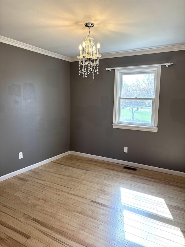 2110 Magnolia Dr, Jacksonville, IL 62650 - unfurnished room featuring crown molding, visible vents, light wood-type flooring, and an inviting chandelier