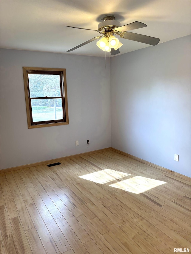 2110 Magnolia Dr, Jacksonville, IL 62650 - empty room with visible vents, ceiling fan, light wood-style floors, and baseboards