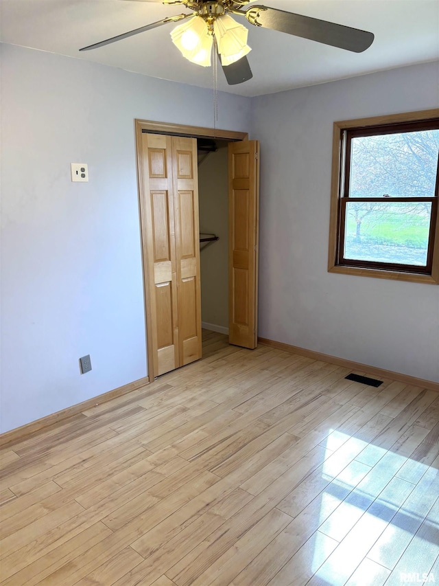 2110 Magnolia Dr, Jacksonville, IL 62650 - unfurnished bedroom with visible vents, baseboards, a closet, light wood-type flooring, and a ceiling fan