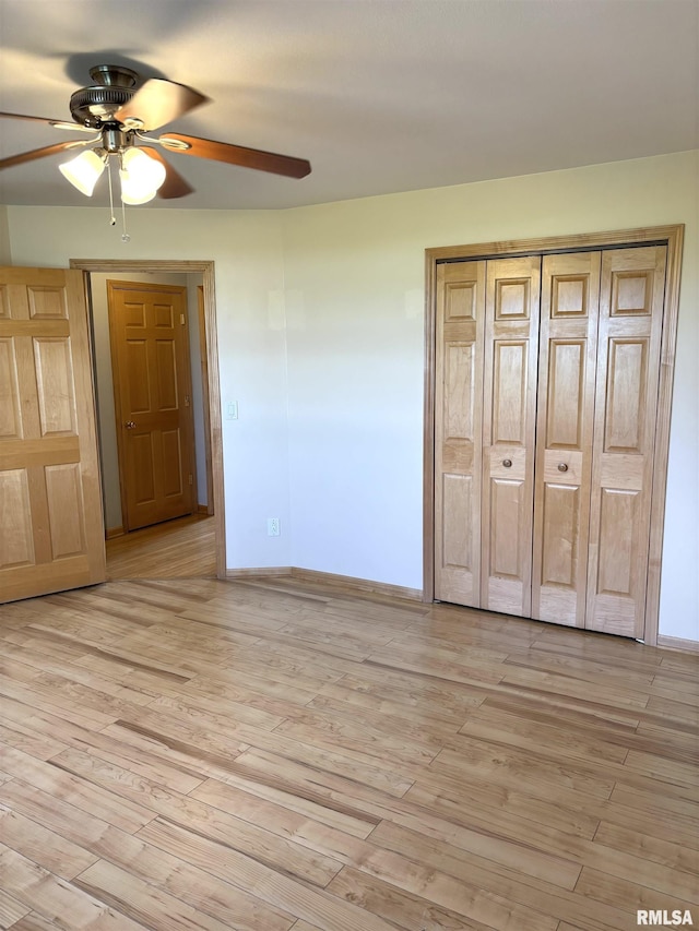 2110 Magnolia Dr, Jacksonville, IL 62650 - unfurnished bedroom featuring a closet, baseboards, light wood-type flooring, and a ceiling fan