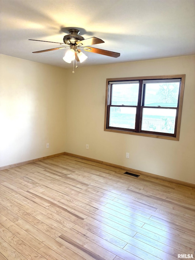 2110 Magnolia Dr, Jacksonville, IL 62650 - unfurnished room featuring visible vents, ceiling fan, light wood-style floors, and baseboards