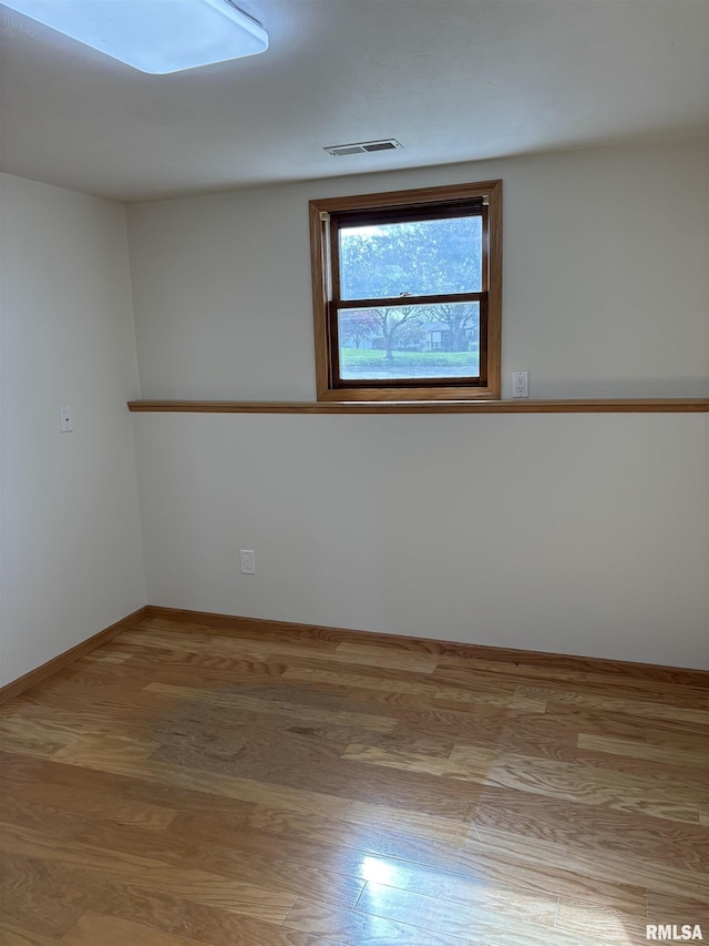 2110 Magnolia Dr, Jacksonville, IL 62650 - spare room with visible vents, baseboards, and wood finished floors