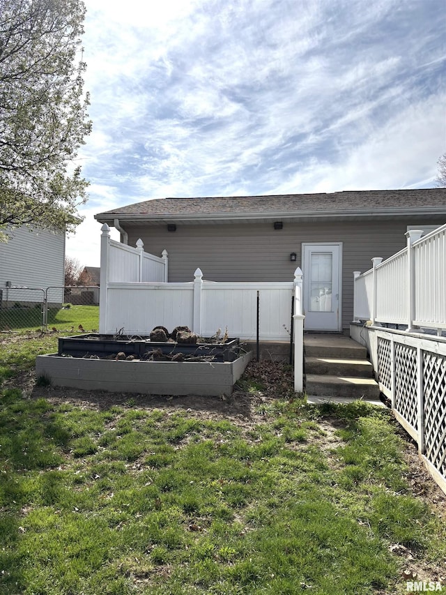 2110 Magnolia Dr, Jacksonville, IL 62650 - rear view of house with a yard, fence, and a vegetable garden
