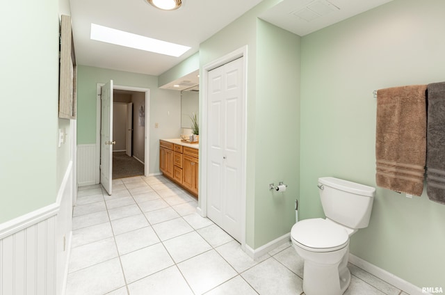 bathroom featuring vanity, visible vents, toilet, tile patterned floors, and baseboards