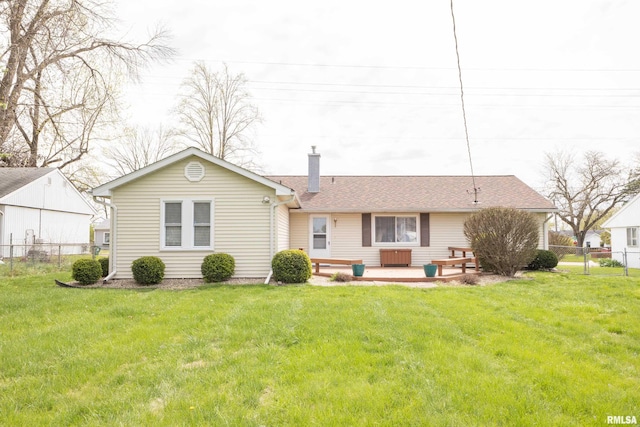 back of property with a yard, fence, and a chimney