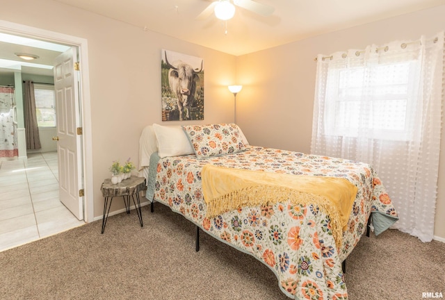 carpeted bedroom with tile patterned floors, baseboards, and a ceiling fan