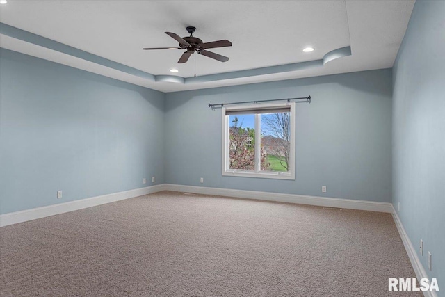carpeted spare room featuring recessed lighting, baseboards, a ceiling fan, and a raised ceiling