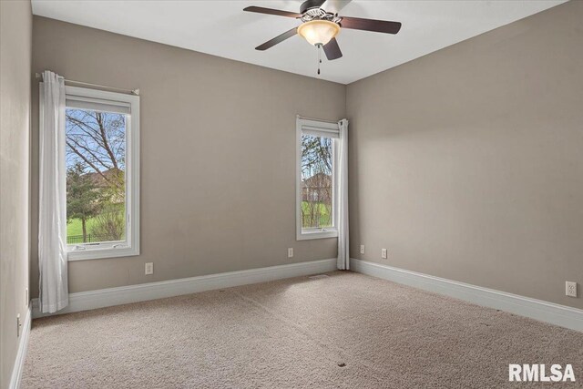 carpeted spare room with baseboards and a ceiling fan