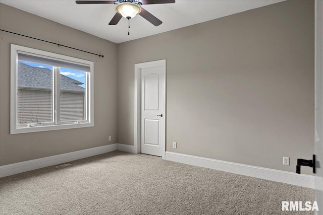 spare room with visible vents, ceiling fan, light carpet, and baseboards