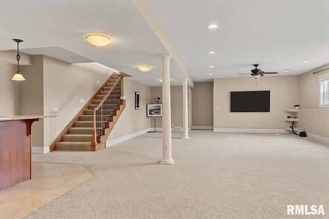 basement with light colored carpet, baseboards, and a ceiling fan