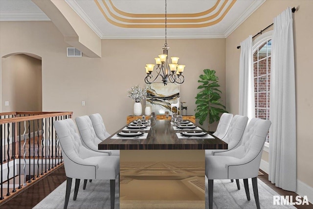 dining space with arched walkways, ornamental molding, visible vents, a chandelier, and a raised ceiling