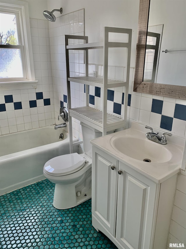 full bath featuring backsplash, shower / bath combination, toilet, vanity, and tile walls