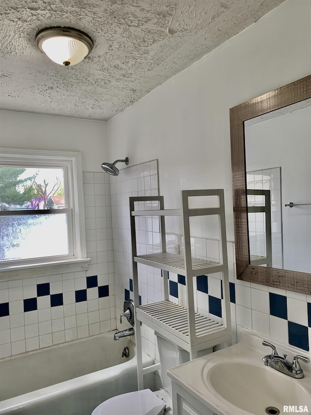 bathroom featuring bathing tub / shower combination, toilet, vanity, tile walls, and decorative backsplash