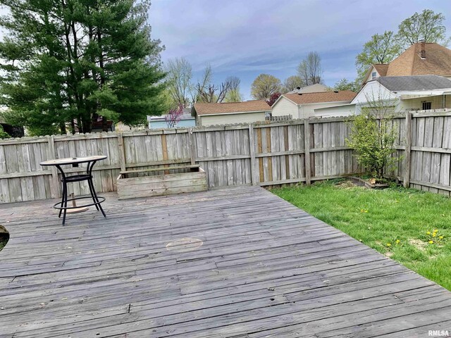 wooden terrace with a fenced backyard