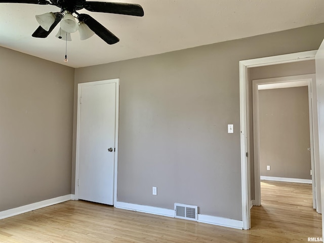 unfurnished room featuring light wood-style floors, visible vents, baseboards, and ceiling fan