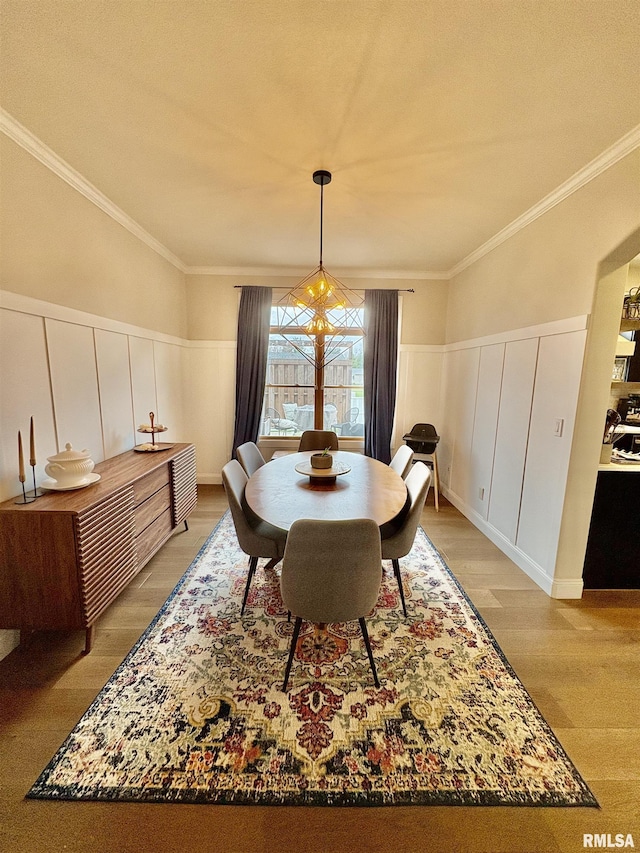 3096 Whitehaven Cir, Galesburg, IL 61401 - dining space with a decorative wall, crown molding, a wainscoted wall, and light wood-style floors