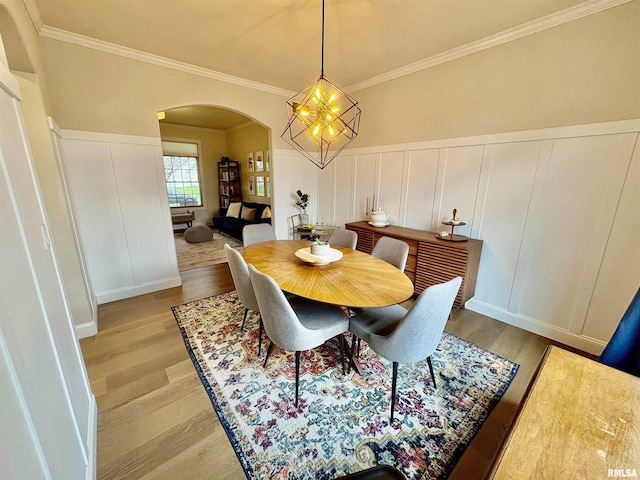 3096 Whitehaven Cir, Galesburg, IL 61401 - dining room with crown molding, light wood-style flooring, arched walkways, and a decorative wall
