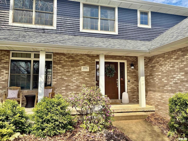 3096 Whitehaven Cir, Galesburg, IL 61401 - doorway to property featuring a shingled roof, covered porch, and brick siding