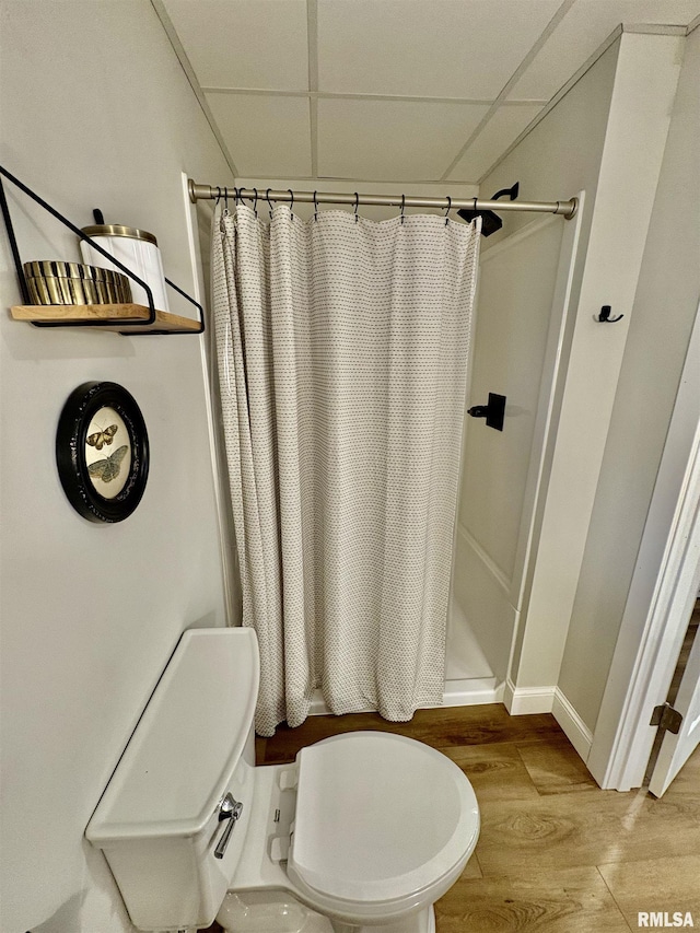 3096 Whitehaven Cir, Galesburg, IL 61401 - bathroom featuring toilet, wood finished floors, a stall shower, baseboards, and a paneled ceiling