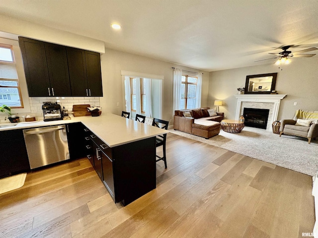 3096 Whitehaven Cir, Galesburg, IL 61401 - kitchen featuring a kitchen breakfast bar, open floor plan, light wood-style flooring, dishwasher, and light countertops