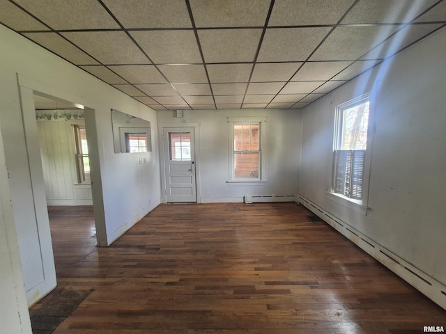 foyer entrance featuring baseboards, wood finished floors, and a paneled ceiling