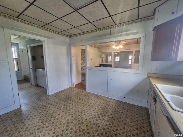 kitchen featuring ceiling fan, tile patterned floors, light countertops, and a sink