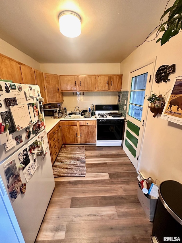 1038 W Maple Ave, Springfield, IL 62704 - kitchen featuring light countertops, backsplash, wood finished floors, freestanding refrigerator, and range with gas stovetop