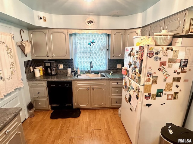 1038 W Maple Ave, Springfield, IL 62704 - kitchen with backsplash, dishwasher, a sink, freestanding refrigerator, and light wood-style flooring