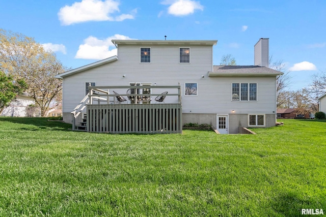 rear view of house with a wooden deck, a lawn, and a chimney