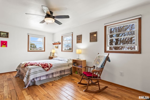 bedroom with ceiling fan, baseboards, and light wood-style flooring