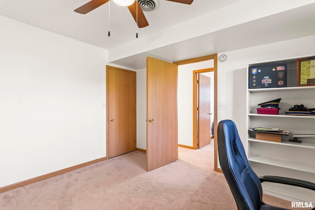 office featuring ceiling fan, visible vents, baseboards, and light carpet