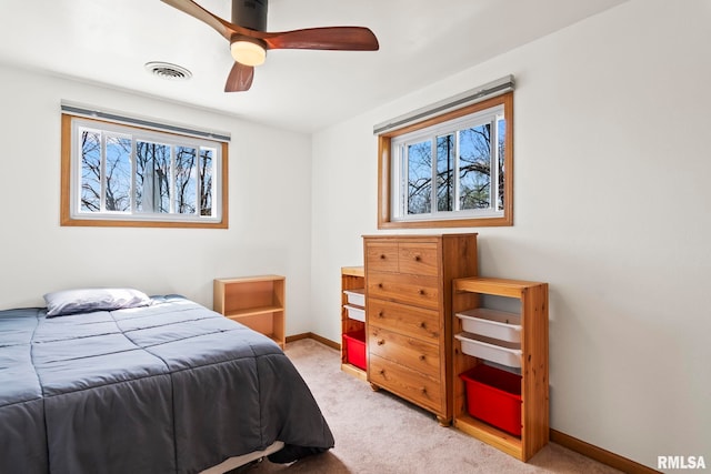 bedroom with light carpet, a ceiling fan, visible vents, and baseboards