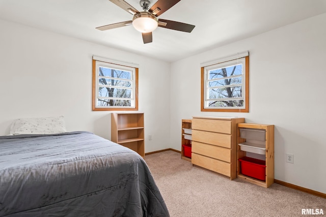 bedroom with light carpet, baseboards, ceiling fan, and multiple windows