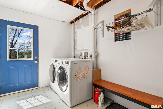 washroom with light floors, washer and dryer, and laundry area