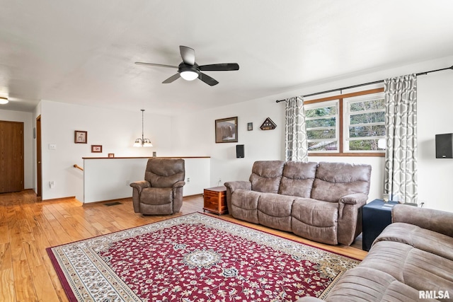 living room with ceiling fan, light wood-style floors, and visible vents
