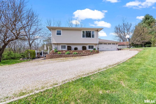 tri-level home featuring a garage, gravel driveway, and a front yard