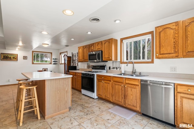 kitchen featuring a wealth of natural light, stainless steel appliances, visible vents, and a sink