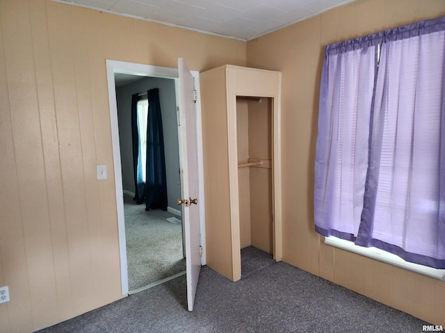 403 S Elm St, Lincoln, IL 62656 - unfurnished bedroom featuring carpet flooring and wood walls