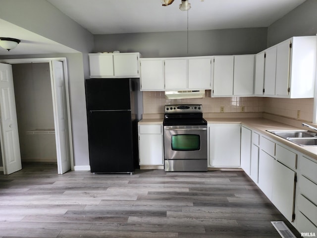 403 S Elm St, Lincoln, IL 62656 - kitchen featuring freestanding refrigerator, stainless steel electric stove, under cabinet range hood, light countertops, and tasteful backsplash