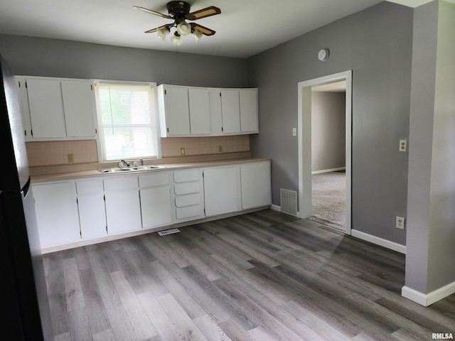 403 S Elm St, Lincoln, IL 62656 - kitchen featuring ceiling fan, decorative backsplash, light countertops, and wood finished floors