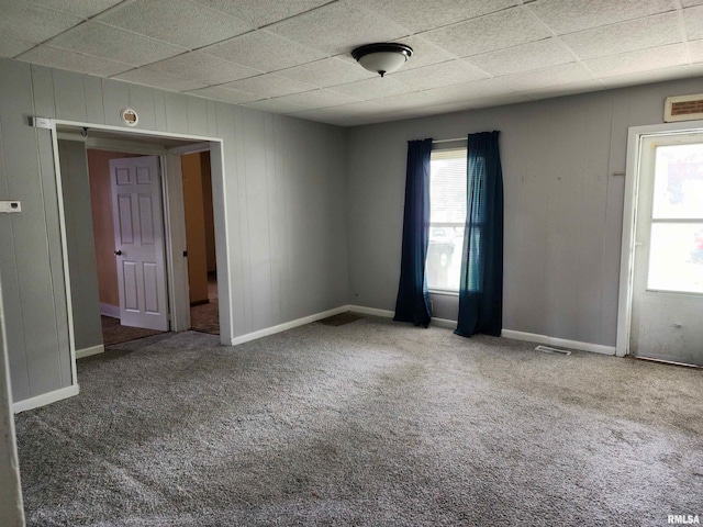 403 S Elm St, Lincoln, IL 62656 - carpeted empty room featuring a drop ceiling and wooden walls