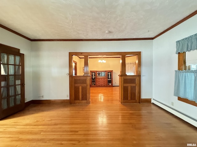 323 E Cortland St, Avon, IL 61415 - empty room featuring a baseboard heating unit, wood finished floors, a chandelier, and ornamental molding