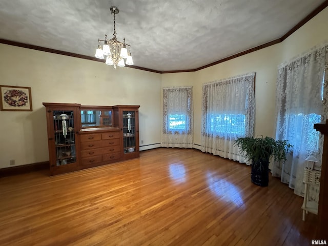323 E Cortland St, Avon, IL 61415 - interior space with hardwood / wood-style flooring, crown molding, a baseboard heating unit, and a chandelier